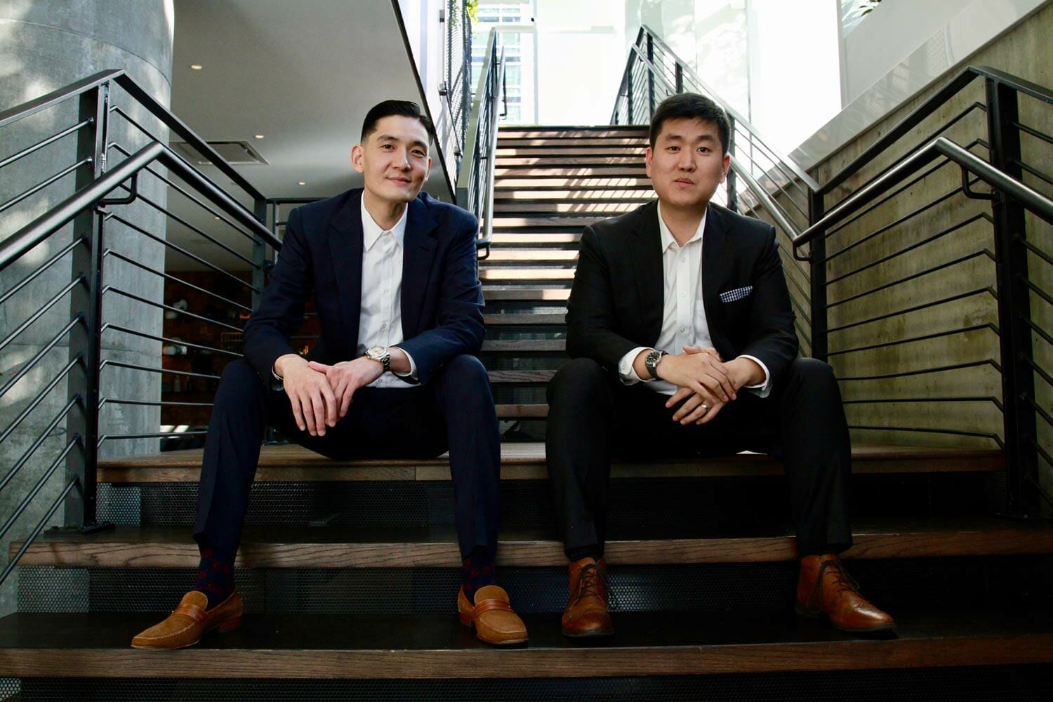 man in black suit jacket sitting beside woman in black blazer