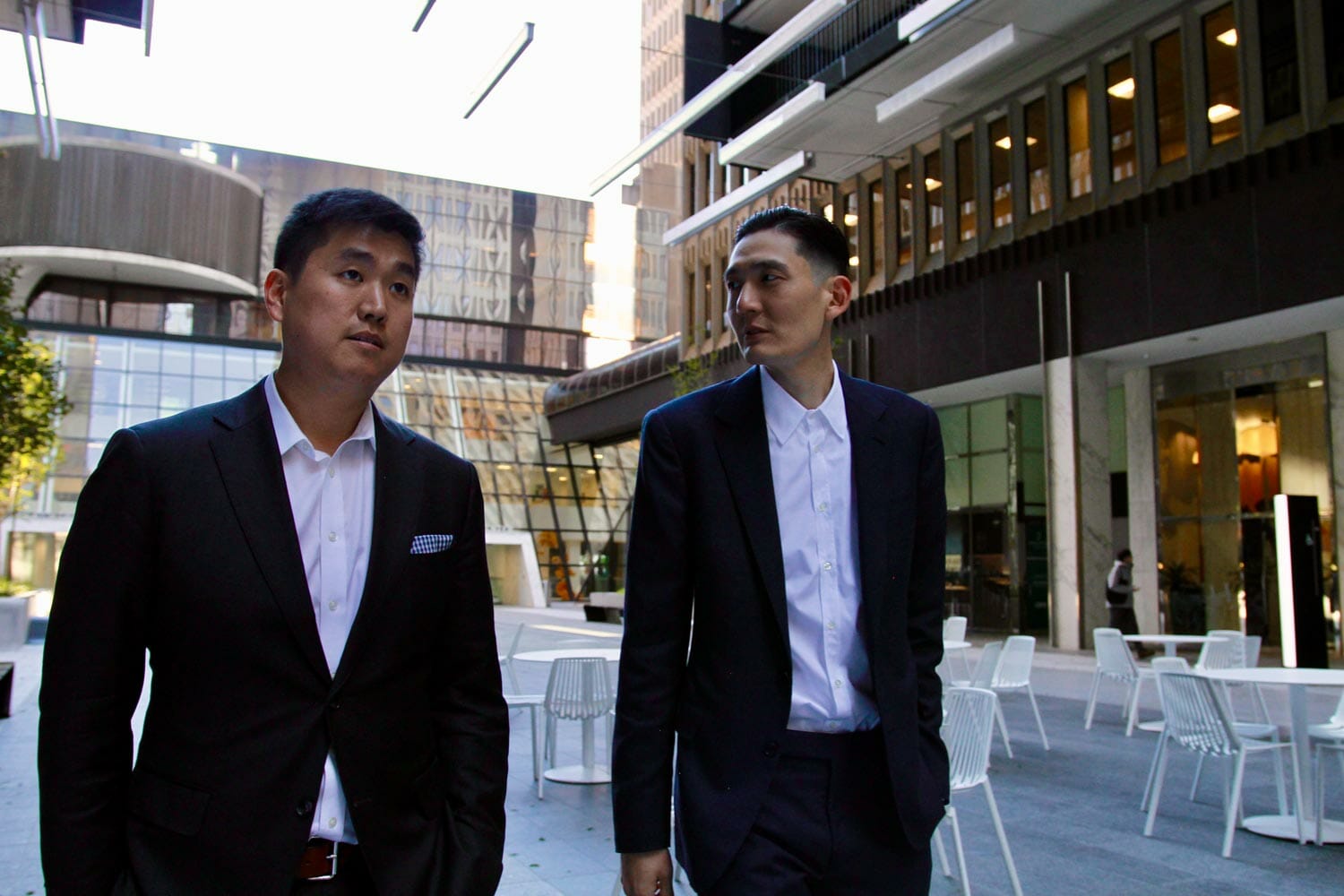 man in black suit jacket standing beside man in black suit